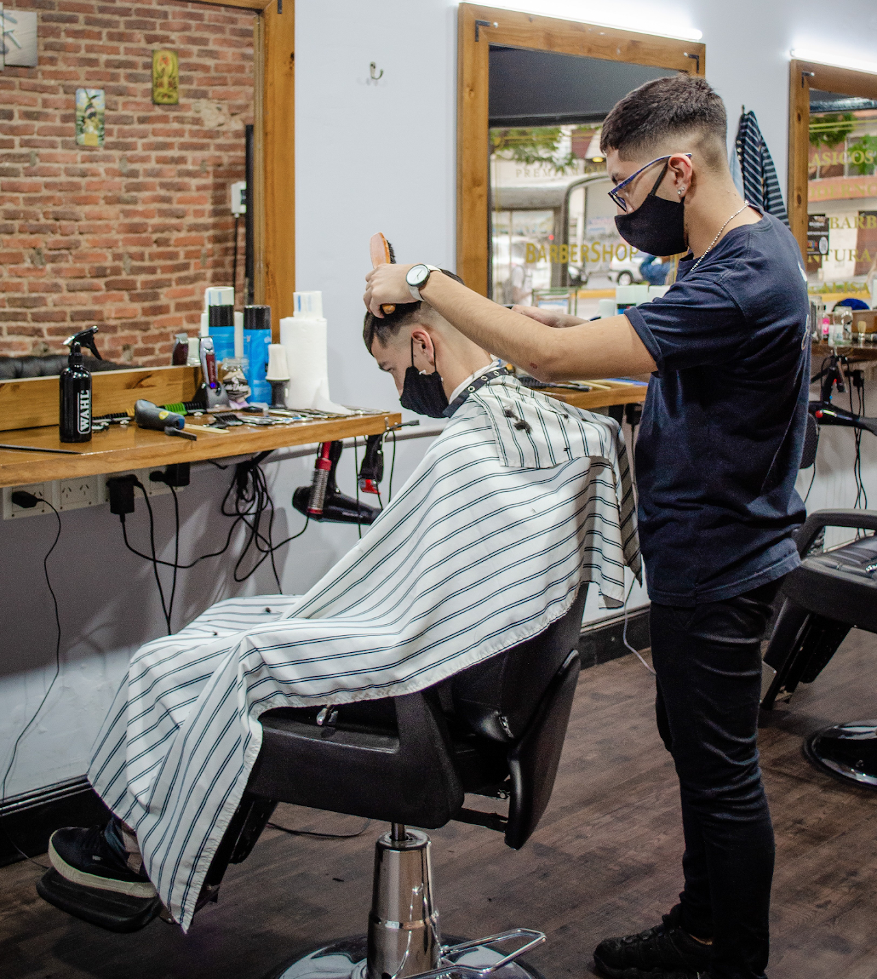 Barbero de Estilo Urbano BarberShop trabajando en un corte de precisión